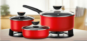 Três panelas vermelhas com tampas de vidro, em tamanhos diferentes, estão dispostas sobre uma superfície de madeira. O fundo da imagem mostra uma cozinha com uma bancada e alguns ingredientes, mas está desfocado para dar destaque às panelas. A iluminação é clara e uniforme, realçando a cor vibrante das panelas e os detalhes dos cabos e tampas.